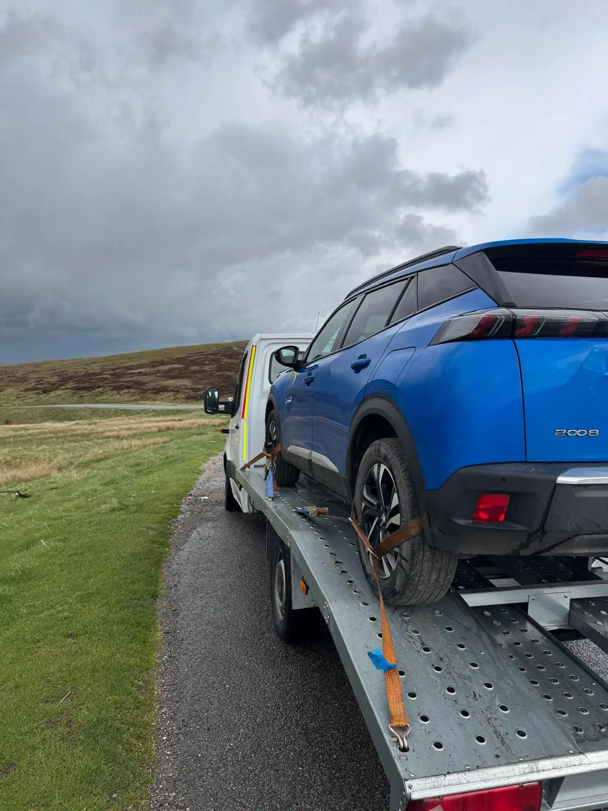 NSY Vehicle Recovery flatbed transporting a blue SUV across the Yorkshire moors
